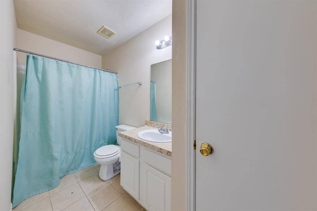 This well-appointed bathroom is shared, with easy access from the hallway—perfect for family convenience and privacy.