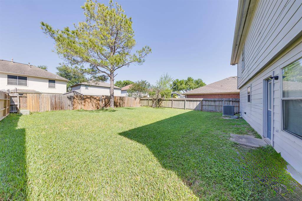 Another angle of the spacious backyard, offering ample room and potential for your dream garden.