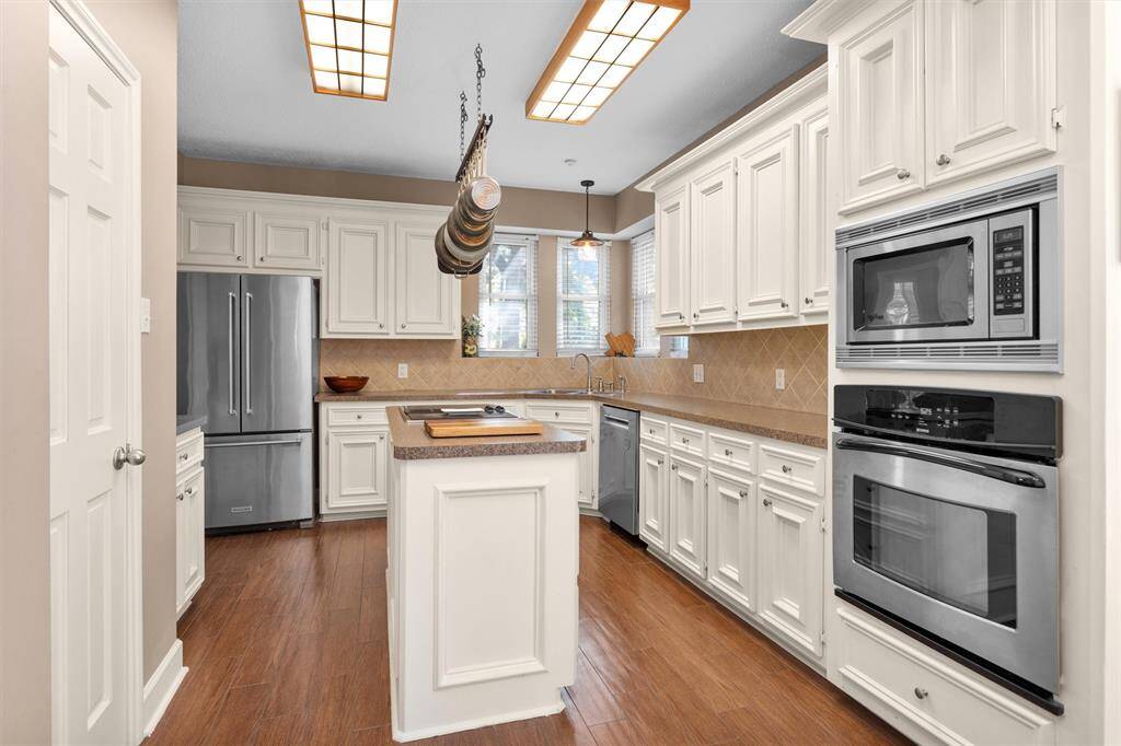 Loads of cabinet space in this island kitchen. Pantry on the left. Electric stove and microwave on the right