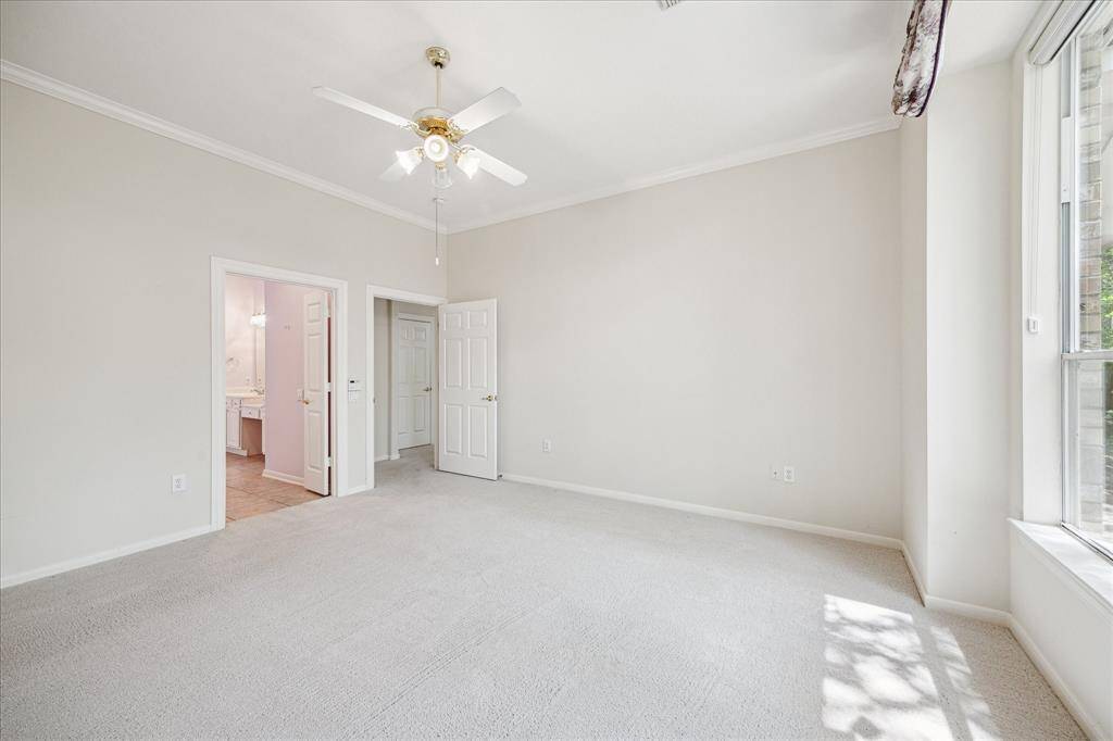Another angle of the spacious primary bedroom, highlighting its generous layout and bright ambiance.