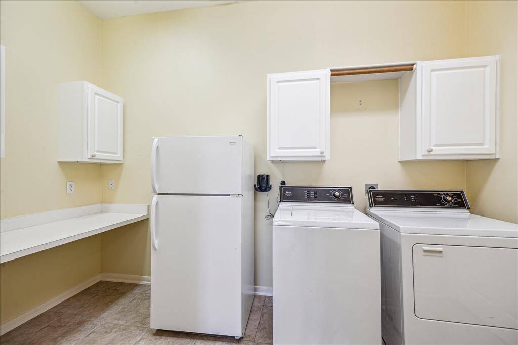 Accessible directly from the garage, the laundry room offers a spacious folding area, plentiful cabinet space, and dedicated hanging space. The refrigerator, washer, and dryer all convey with the property.
