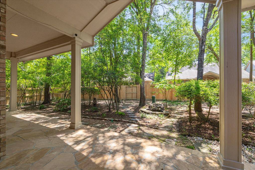 The covered patio, featuring high ceilings, creates an ideal space for outdoor activities and relaxation. Its spacious design offers shade and comfort, making it a perfect setting for unwinding or entertaining in a serene outdoor environment.
