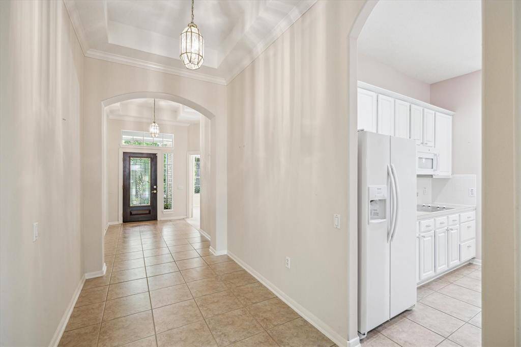 Step into the stunning front entryway, where a beautifully designed front door opens to the soaring high ceilings that create a bright and spacious feel. This elegant entrance sets the tone for the rest of the home, combining charm and warmth from the moment you walk in.