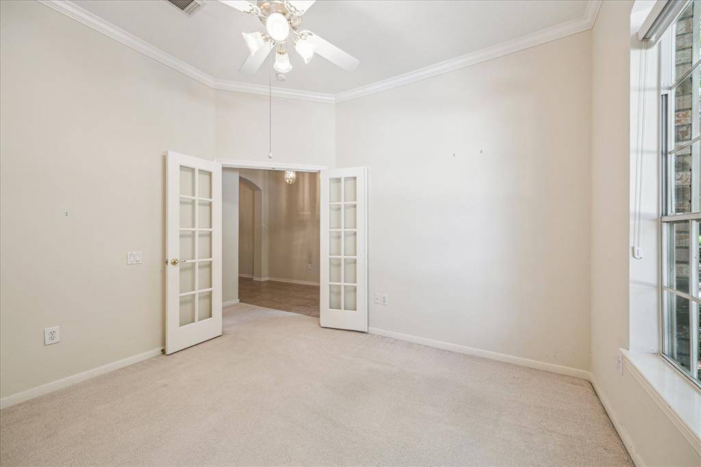 Another perspective of the spacious office, showcasing the elegant French doors that enhance the room's bright and light-filled atmosphere.