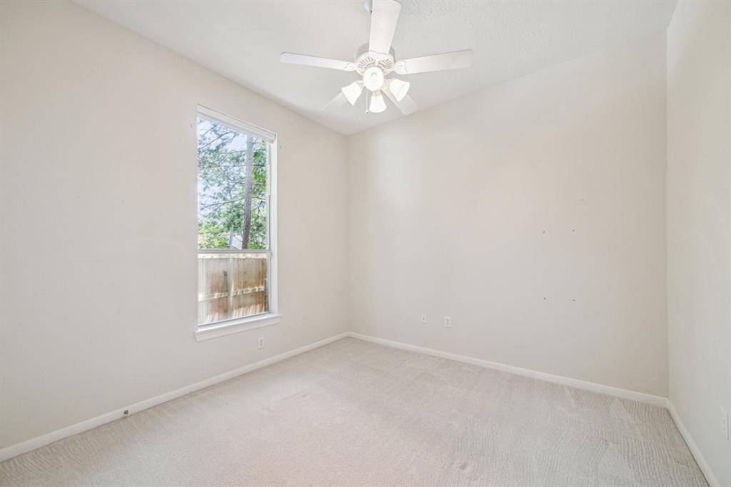 The generously sized secondary bedroom features a spacious walk-in closet and large windows that allow an abundance of natural light to fill the room, creating a bright and inviting atmosphere.
