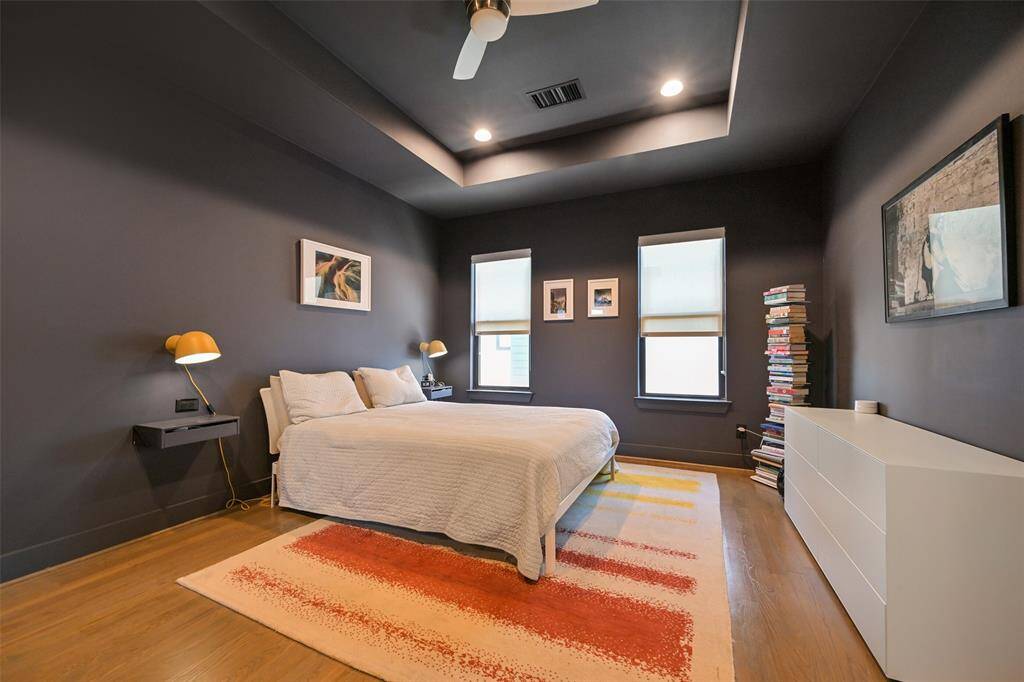 Primary bedroom makes relaxing easy with the moody dark paint and tray ceiling.