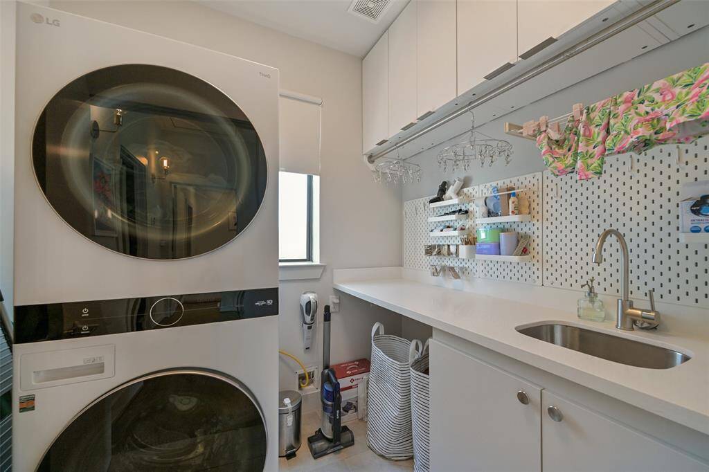 There is generous space in the utility room with sink, storage and drying rack.  LG stackable washer and dryer stay with the home. Located on the 3rd floor near the primary suite.