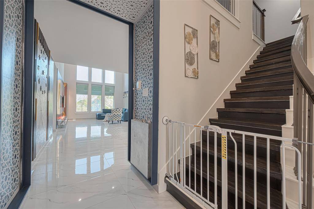 Step into a grand entryway with soaring ceilings, beautifully lit wood stairs, and 8ft upgraded doors throughout the main living spaces that elevate the sense of scale and style. Rich large-format tile flooring spans the main areas, complemented by new plush carpeting upstairs!