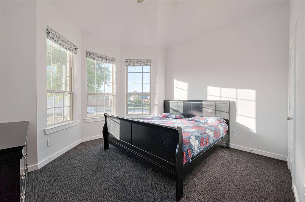 A front-facing guest bedroom impresses with a curved wall of windows, walk-in closet, and new plush carpet.