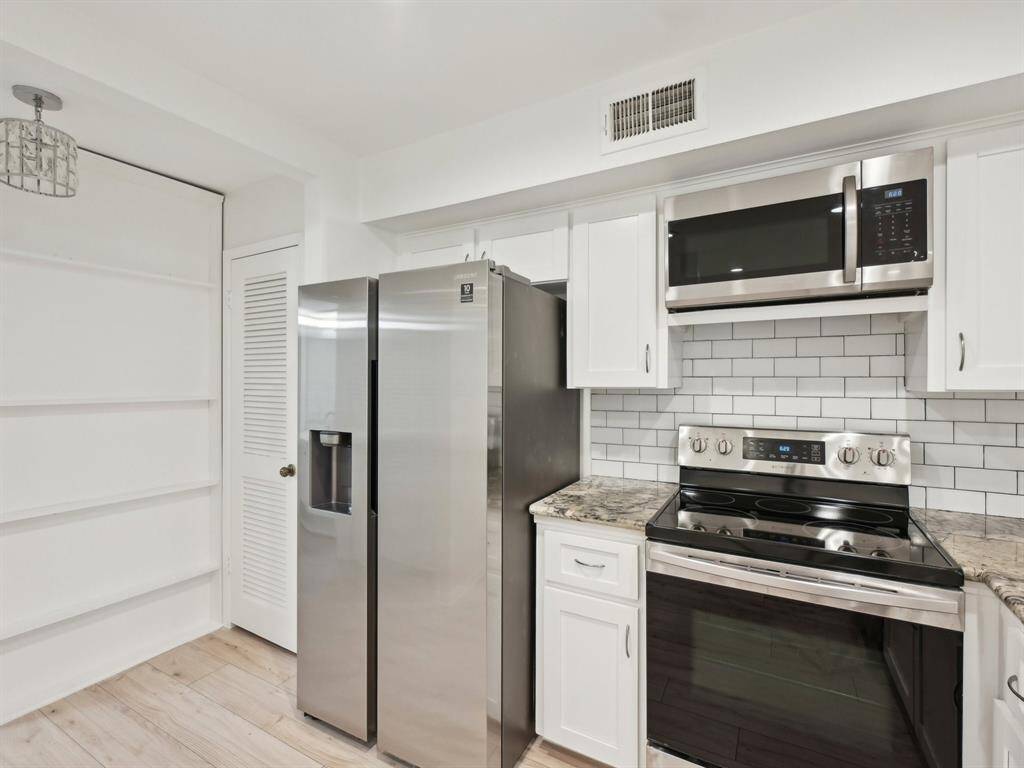 There is shelving to the left, perfect for storing spices or your favorite photos. The pantry is just to the left of the refrigerator.