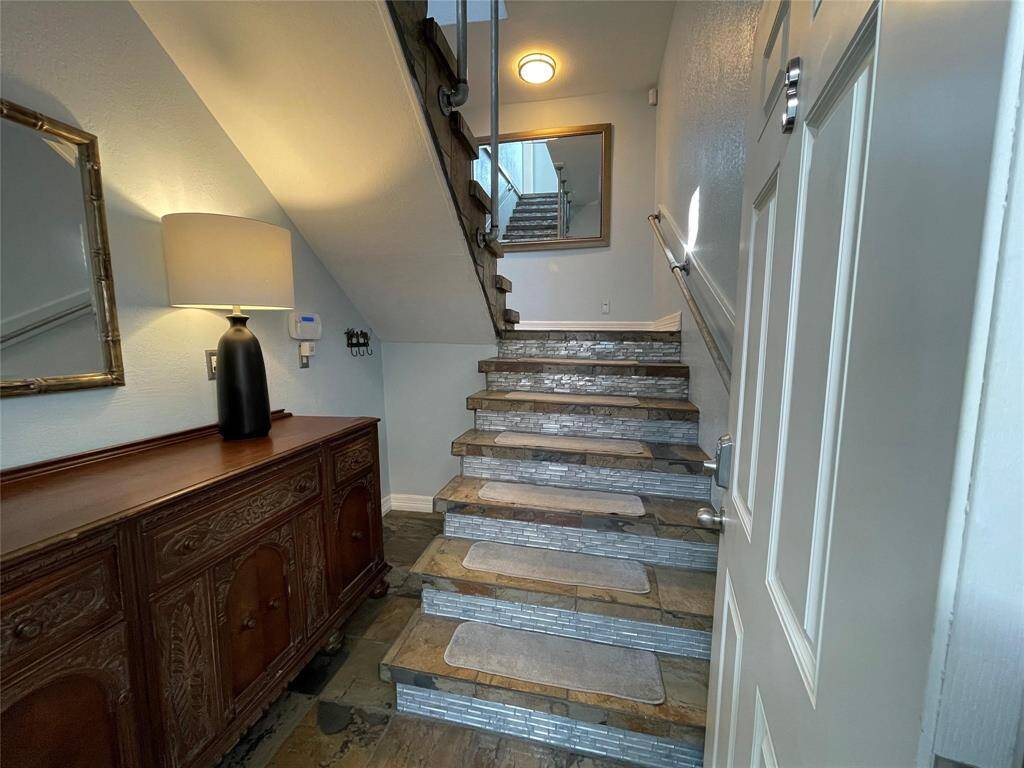 tylish and inviting entryway with a staircase featuring stone accents. This leads up to your apartment. The landlord lives downstairs.