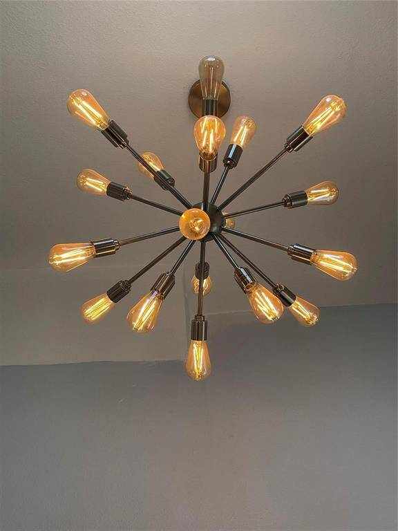 odern, starburst-style chandelier with multiple exposed bulbs, adding an elegant and contemporary touch to the room.