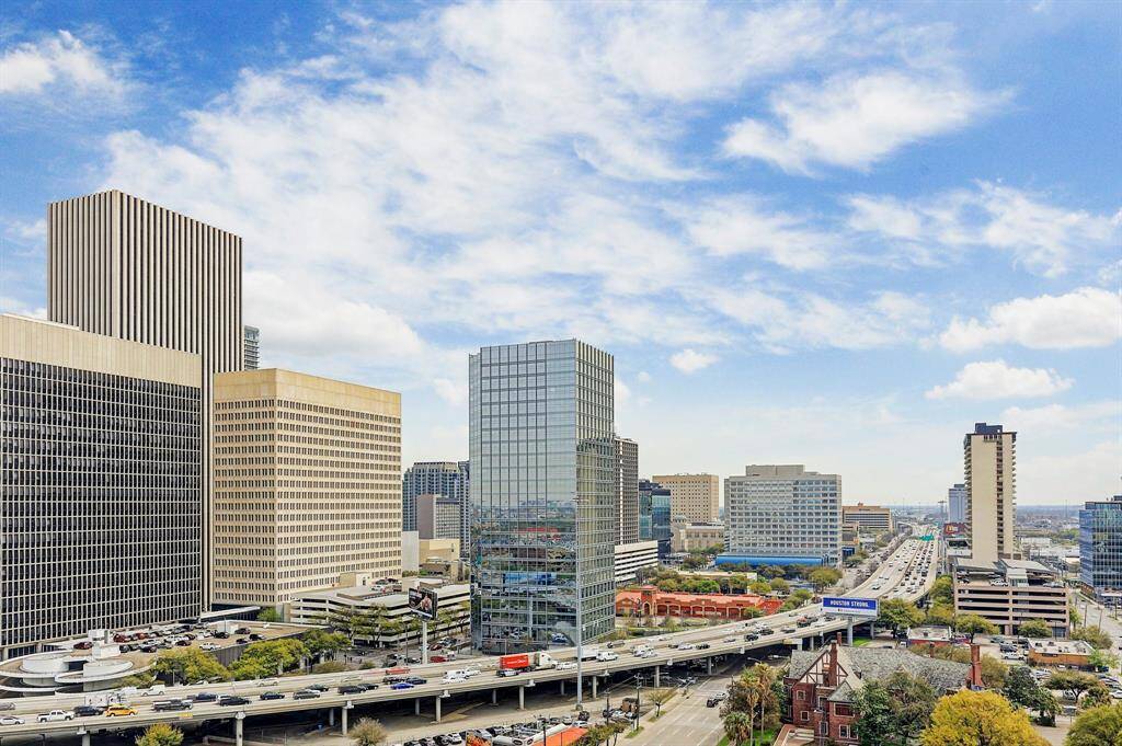 The photo showcases a bustling urban skyline with modern high-rise buildings and a busy highway, highlighting the vibrant city atmosphere. Perfect for those seeking a dynamic urban lifestyle.