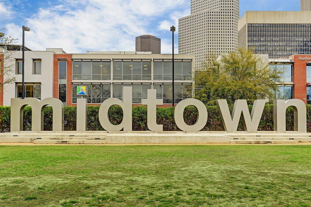 Large "Midtown" sign in a vibrant urban setting, with modern buildings and greenery, highlighting a lively neighborhood atmosphere.