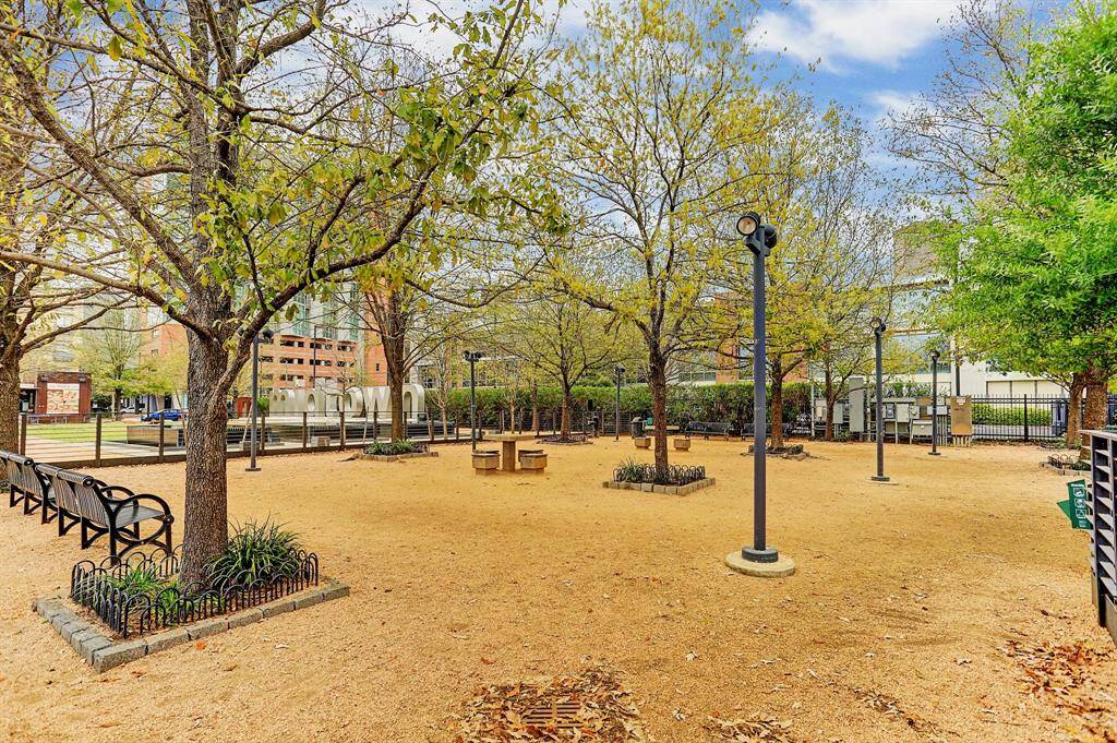 Charming park view featuring a tree-lined area with benches and lampposts, offering a serene outdoor space. Ideal for relaxation and community gatherings in an urban setting.