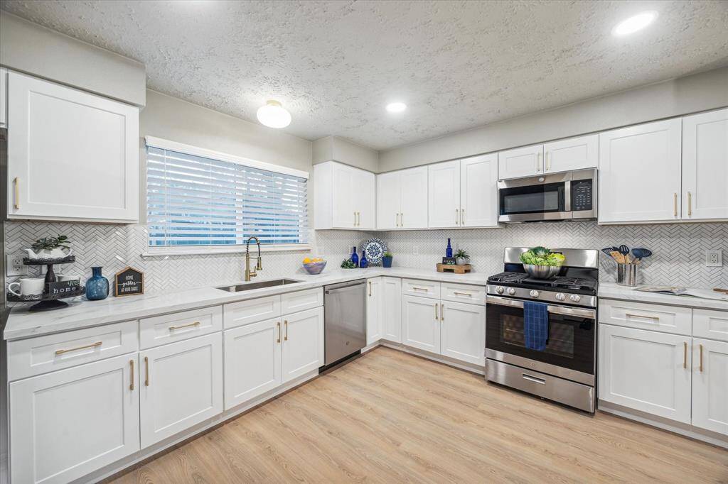 You'll love the large window above the sink brings that brings in natural light and let's you watch the kids or pets play, complementing the recessed lighting for a well-lit workspace. Stainless steel appliances and ample storage make this kitchen as functional as it is beautiful.