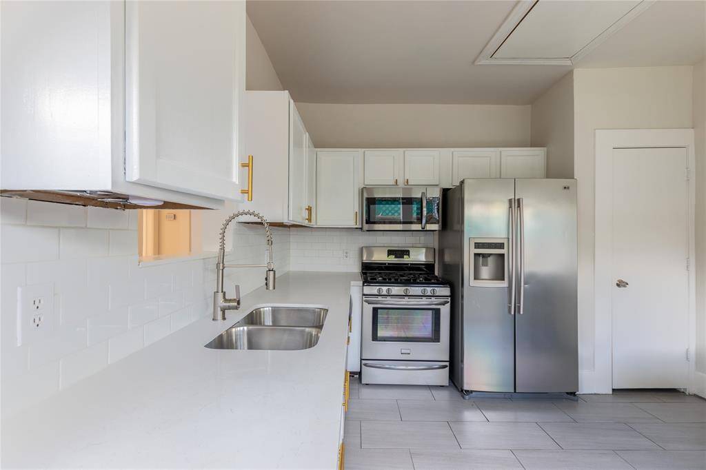 Another view of kitchen with quartz counters and subway style backsplash.
