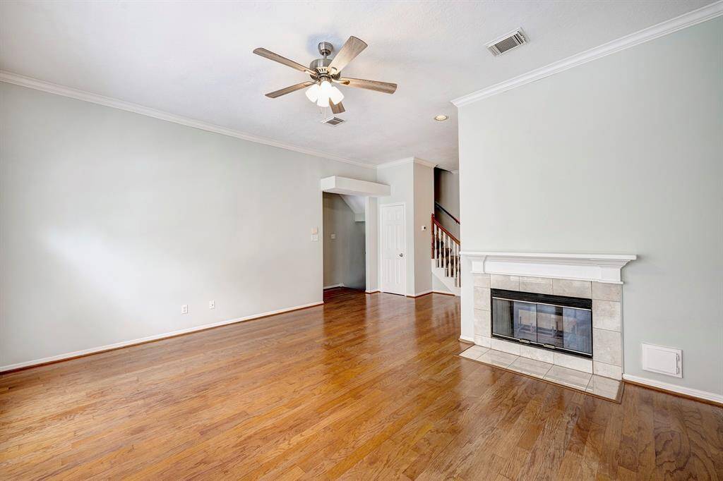 The second-floor living space features wood floors and a double-sided fireplace that connects the living and dining areas.