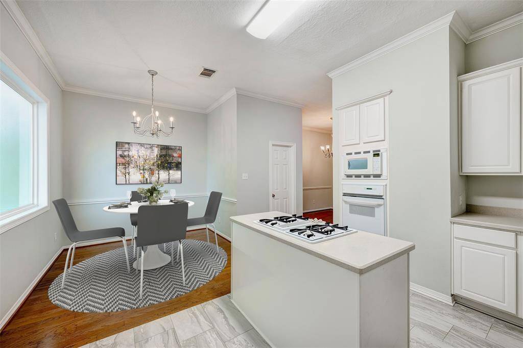 The island kitchen boasts a sunny breakfast nook perfect for casual dining. Virtually staged photo.