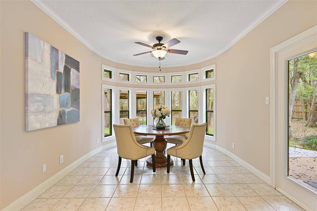 A sunlit breakfast room is tucked in between the family room and the kitchen, at the base of the staircase. Imagine enjoying your morning coffee or a casual meal in this light and bright space with panoramic views of the backyard.
