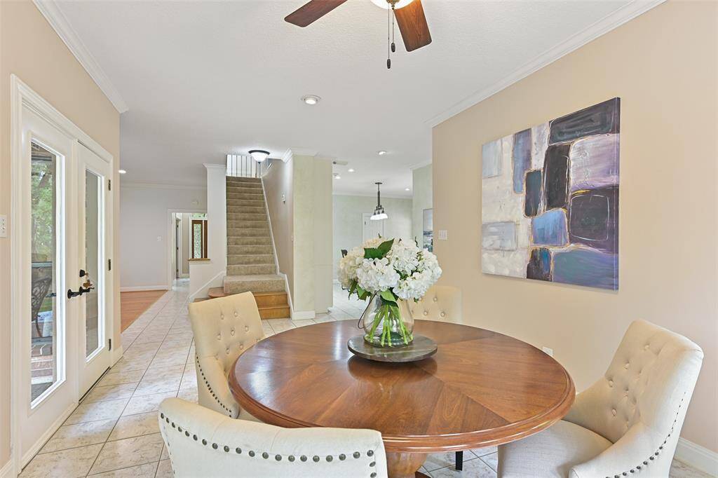 A sunlit breakfast room is tucked in between the family room and the kitchen, at the base of the staircase. Imagine enjoying your morning coffee or a casual meal in this light and bright space with panoramic views of the backyard.