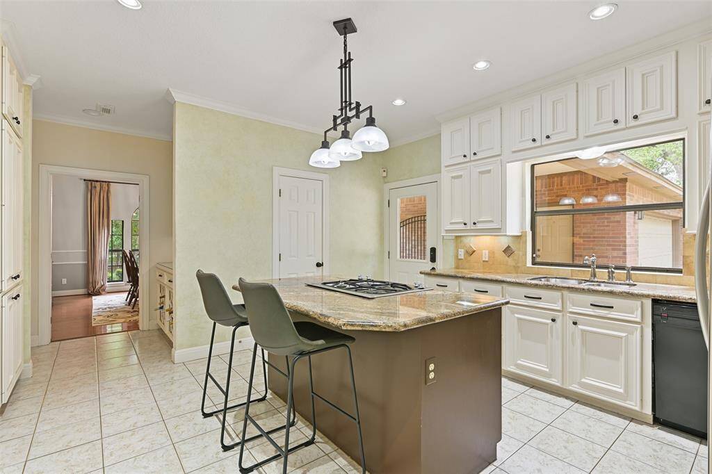 A half-panel glass side door leads from the port cochere into the kitchen and there are also French doors in the breakfast room leading out to the covered back patio - making for a seamless entertaining space. Also, note the butler's pantry/wine bar area between the kitchen and dining room.