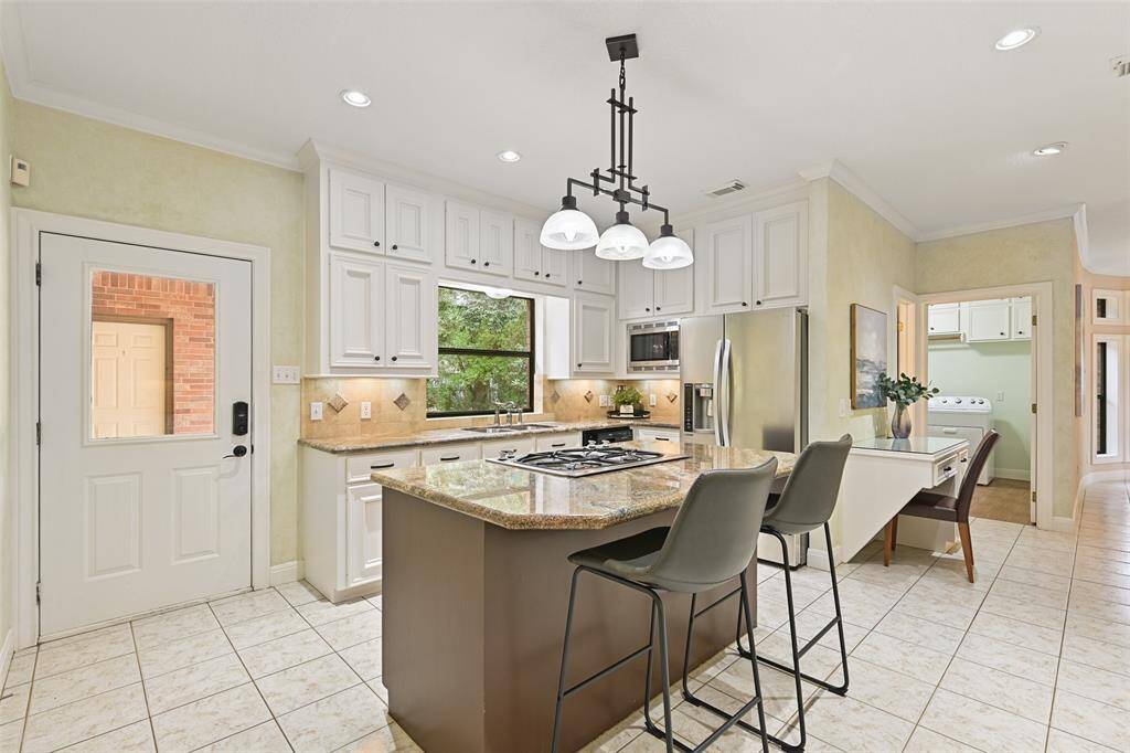 The chef of the house will surely appreciate the ample storage space in the huge walk-in pantry, the dual basin stainless sink, and the appliances include a Jenn Aire 4 burner gas cooktop with downdraft, a 30" electric oven, a dishwasher, and a microwave.
