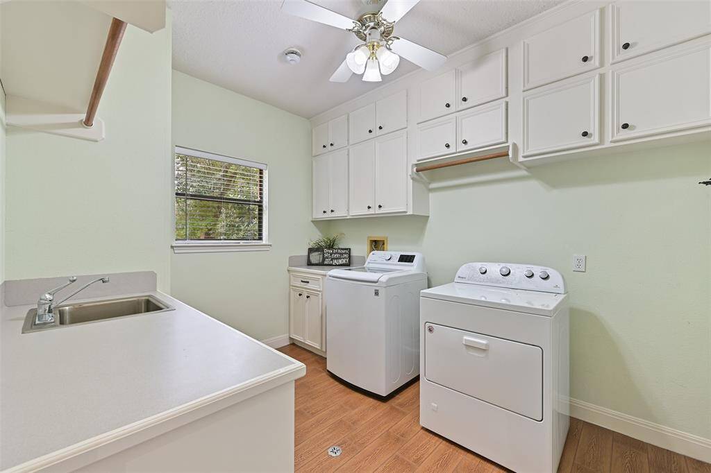 Even the utility room is noteworthy in this home! It measures an impressive 11'x9' and boasts wood-look tile floors, a countertop with a utility sink, hanging & cabinet storage, laundry basket storage, a wall-mounted ironing board, and gas or electric dryer hookups.