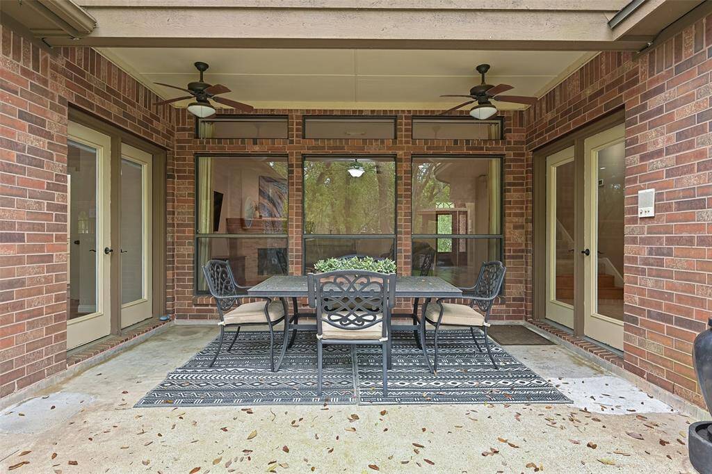 A covered back patio is accessible from French doors in the master suite or the breakfast room. Here, you'll enjoy the breeze from a pair of lighted ceiling fans and a newly poured pathway out to the back deck with the spool.