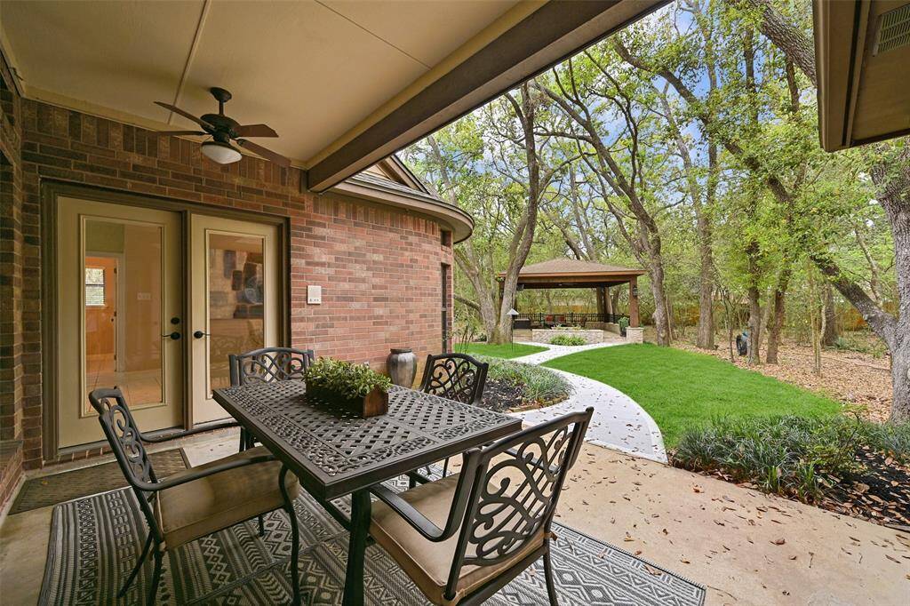 A covered back patio is accessible from French doors in the master suite or the breakfast room. Here, you'll enjoy the breeze from a pair of lighted ceiling fans and a newly poured pathway out to the back deck with the spool.