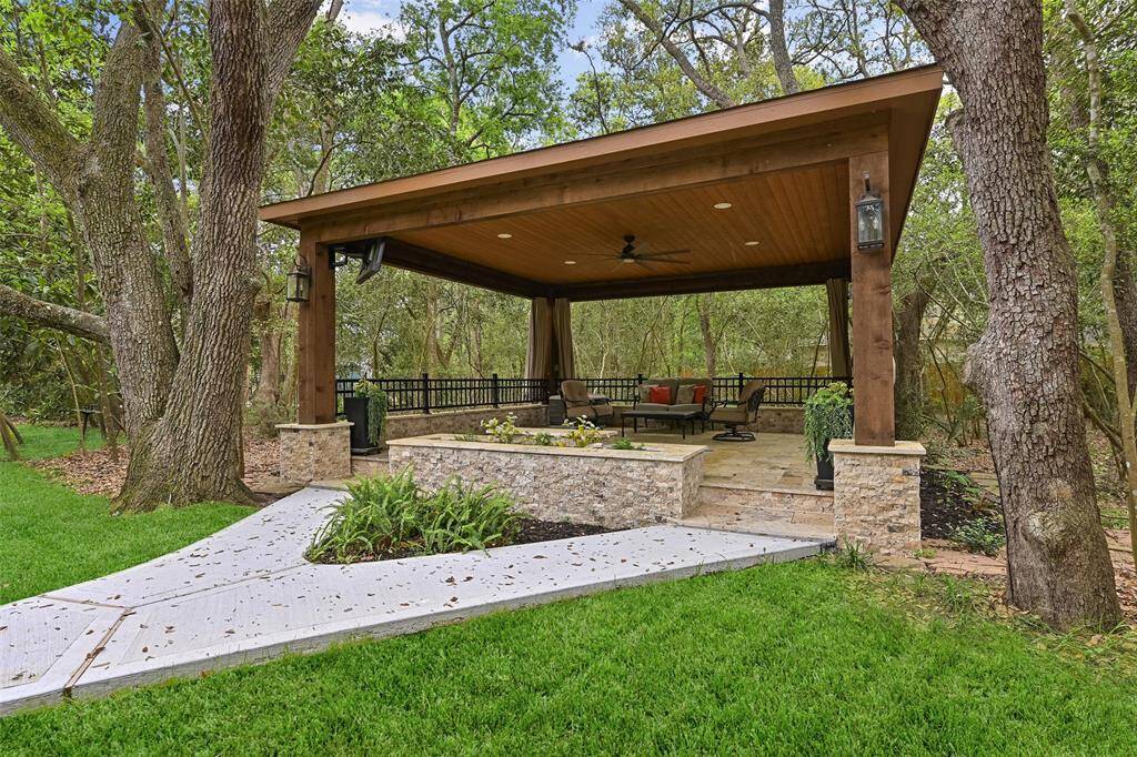 Enjoy the backyard retreat, complete with an in-ground sprinkler system, landscape lighting, a mosquito misting system, a recent privacy fence, and a newly poured concrete pathway leading to the covered patio with travertine tile floors, recessed lighting, a fan, TV capabilities, and a relaxing spool.