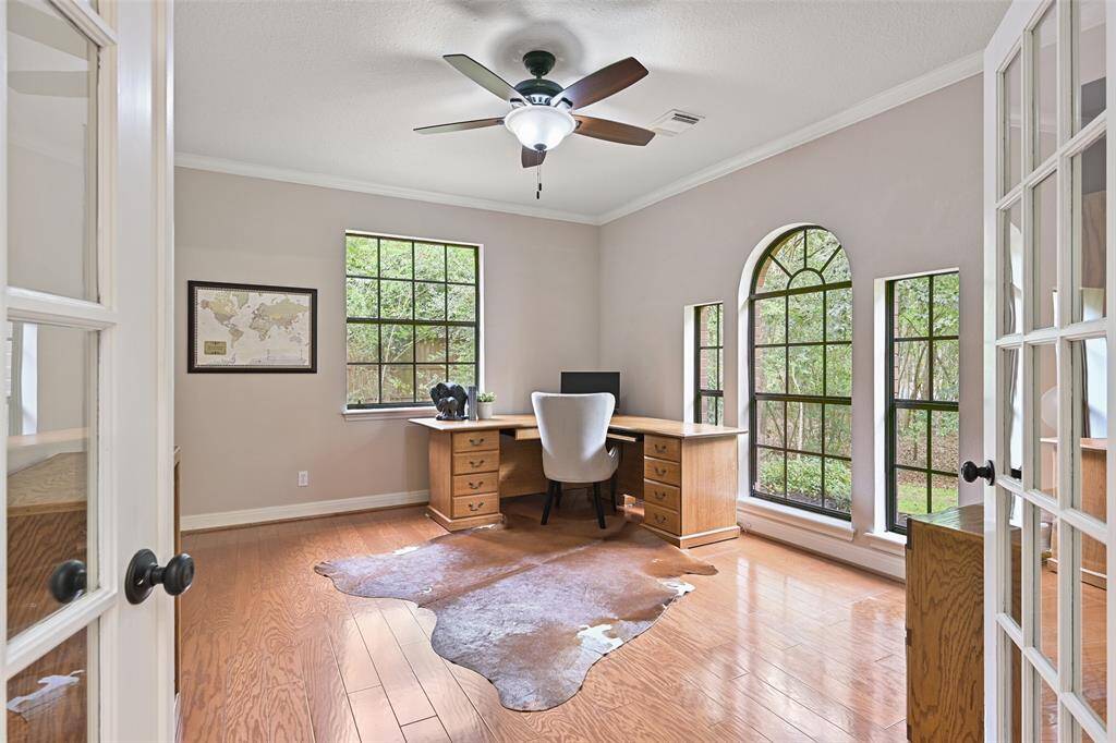 Across the foyer from the dining room, this secluded study with a French door entrance features continued wood floors, a lighted ceiling fan, abundant sunlit windows, and a huge double-door walk-in closet with shelving.