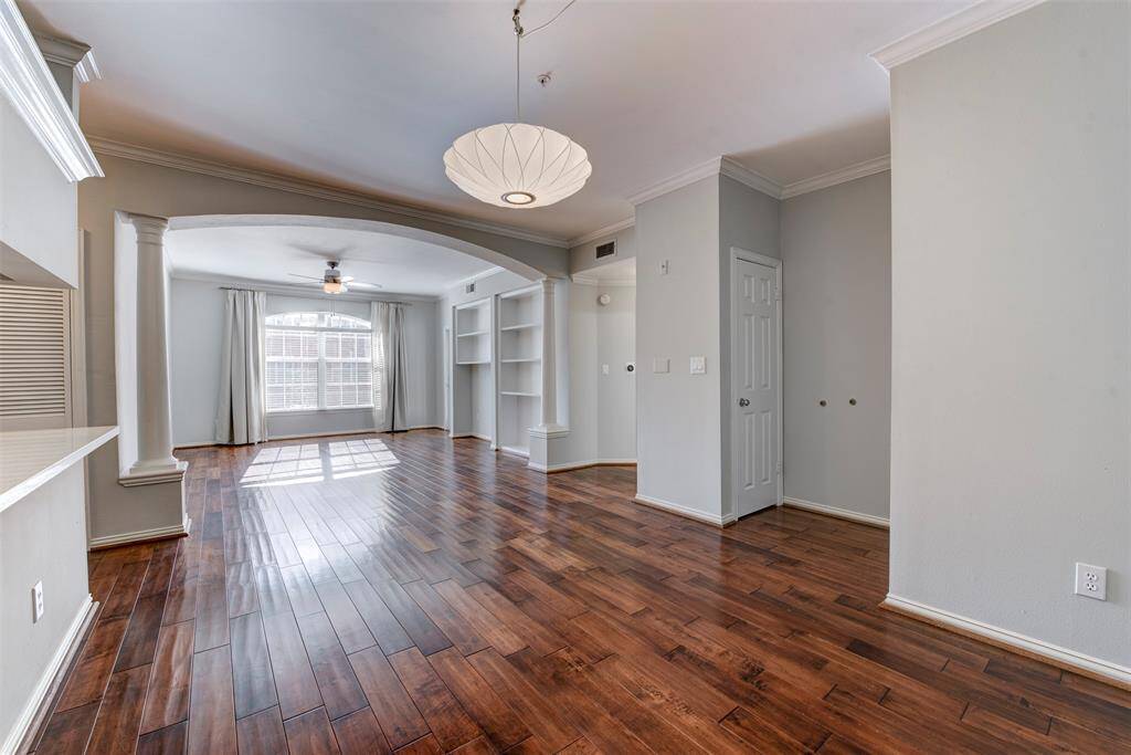 Bright and airy living space with shiny hardwood floors, fresh neutral walls, and sleek modern fixtures. Crown molding throughout adds a nice finishing touch