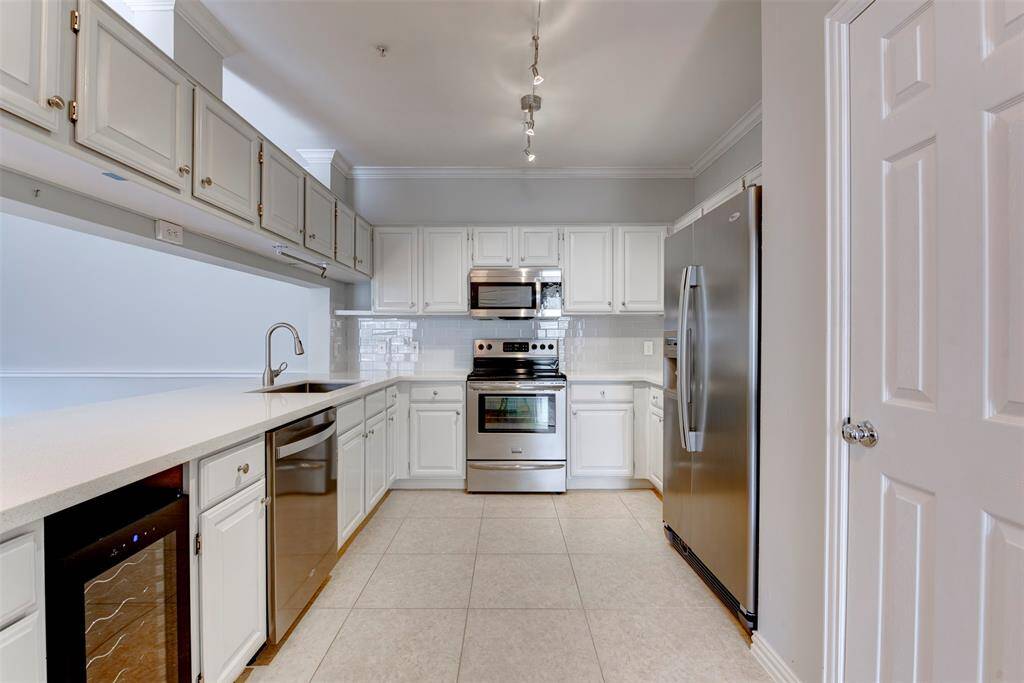 A well executed kitchen offers excellent countertop and storage space. Cabinets are freshly painted, and a brand new wine chiller (2025) is conveyed with the sale.