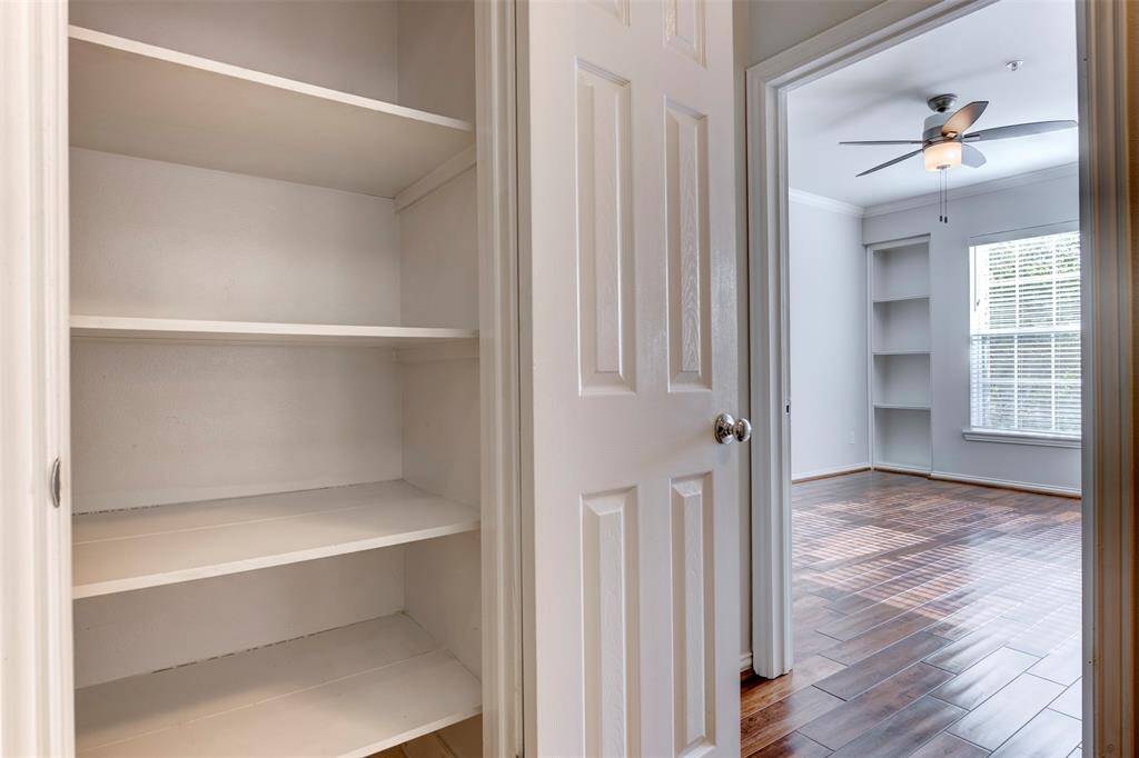 Just to the side of the kitchen, a sizable pantry with deep shelving is placed for storage and convenience.