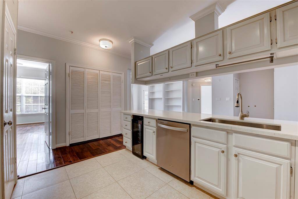 Alternate angle of the bright kitchen with modern appliances, top and bottom cabinetry, and direct access to both the primary bedroom, and your living area