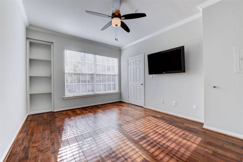 The owner’s retreat offers hardwood floors throughout, a large window allows the easy flow of natural light, built-in shelving is offered for convenience and a mounted TV is conveyed with the sale of the home.