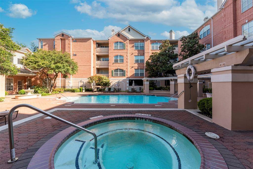 Alternate view of the residential complex with a spacious, inviting pool and a cozy hot tub. The landscaped surroundings provide a serene and comfortable atmosphere, ideal for relaxation and leisure.