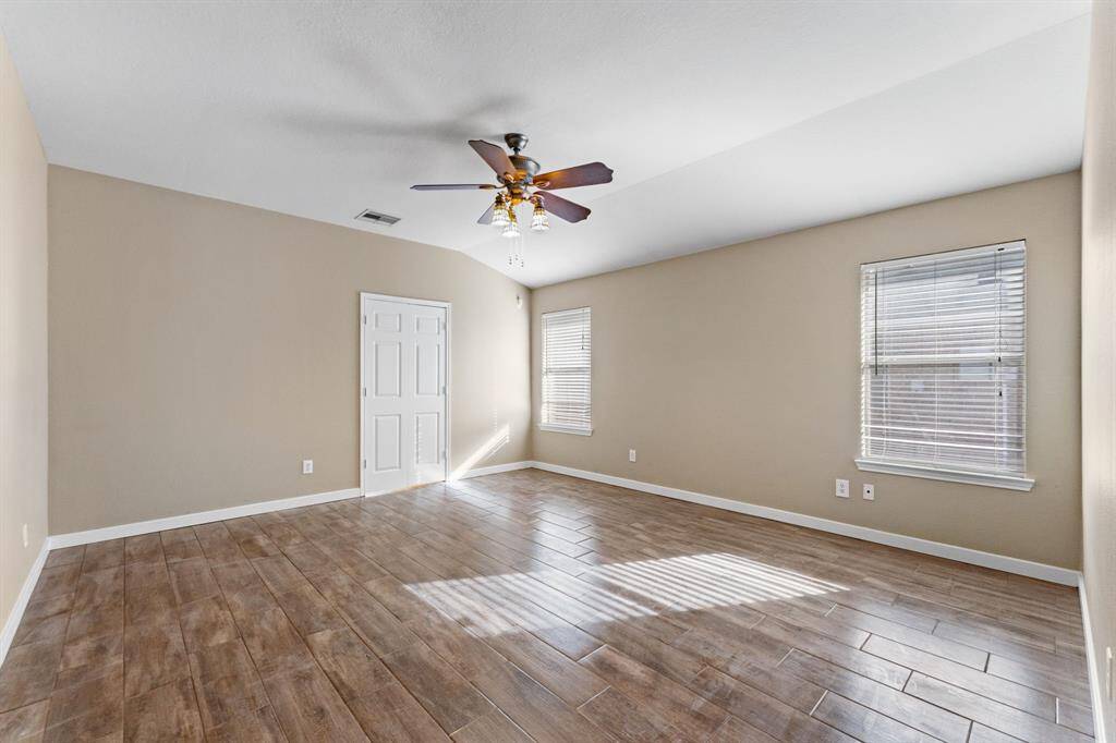 Primary bedroom with tile floor and plenty of natural light.