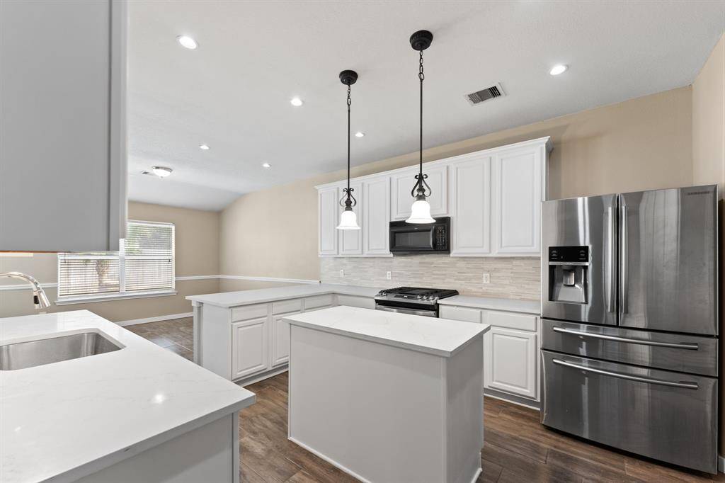 Quartz countertops, stainless steel appliances, stacked tile backsplash