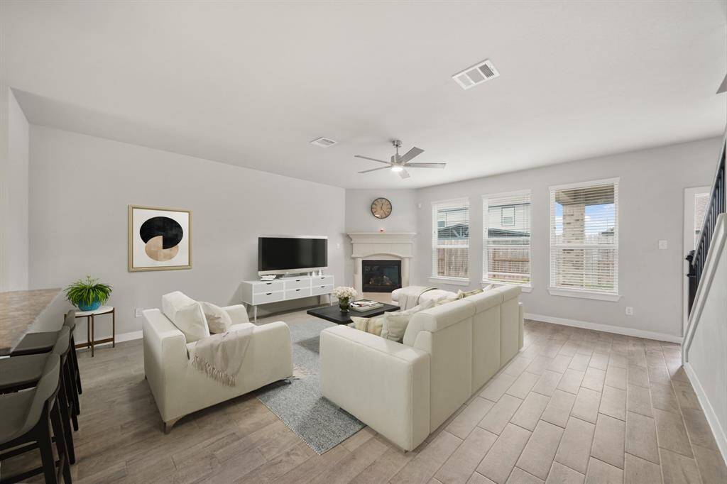 Virtually Staged: This stunning living room features showcases tile floors, a gorgeous fireplace with mantle, and large windows with privacy blinds.