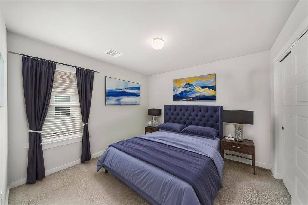 Virtually Staged: Secondary bedroom wtih carpet floors, a window with privacy blinds, and a built-in closet.