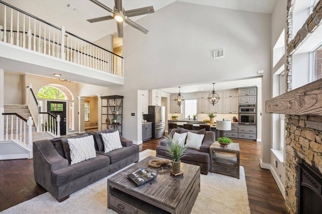 LIVING/KITCHEN  From this angle, a catwalk above is shown.  At left upstairs is the game room and an ensuite bedroom.  At right of the catwalk are two more bedrooms and a shared bath.