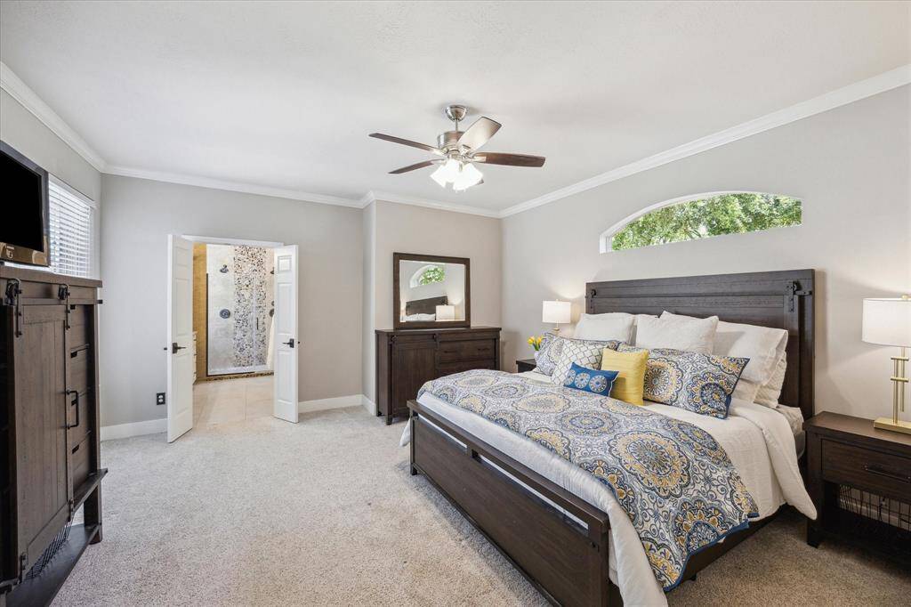 PRIMARY BEDROOM Tucked at the rear right of the home, through an enclave, this bedroom is secluded and quiet.  The arched window above the bed is an architectural detail that provides natural light.