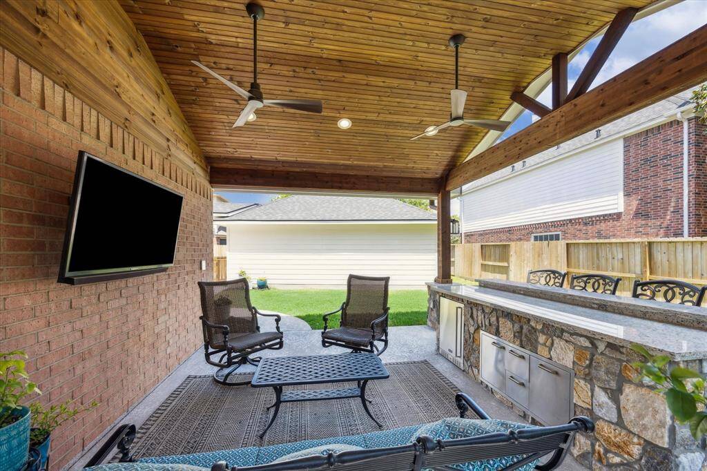 OUTDOOR PATIO A fortune was spent on the outdoor pavillion. Sunbrite TV and Coyote refrigerator will convey. Ample greenspace is seen here, plenty of room for a pool.