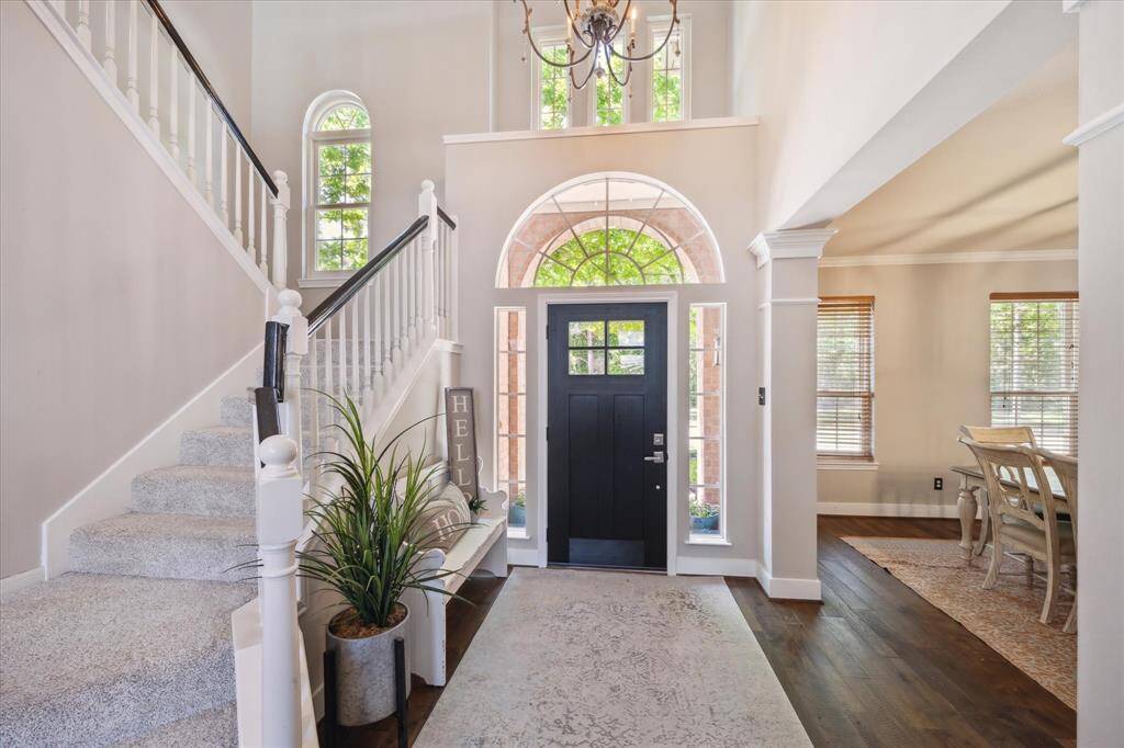 ENTRY  First impressions are important.  Visitors will be greeted with this light filled and airy two story foyer boasted an updated front door and high end chandelier.