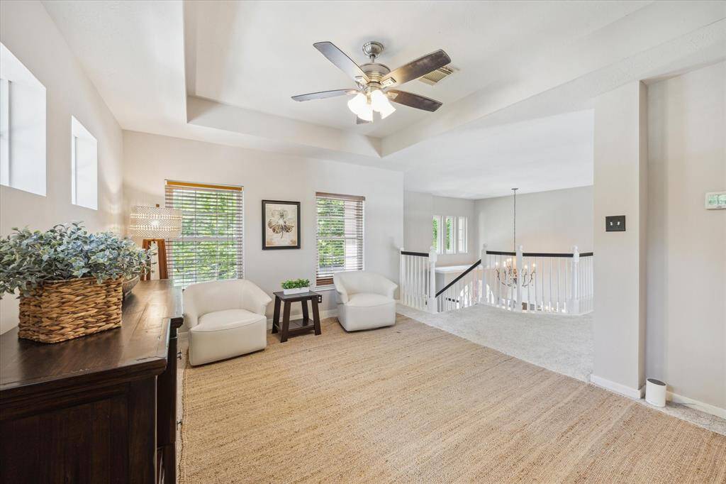 GAME ROOM  Situated at the top of the stairwell is this flexible space with trayed ceiling and updated fan.  Designer paint color throughout the home.