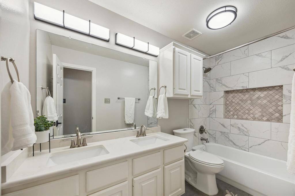 SECONDARY BATH UPSTAIRS  This sizable and completely remodeled bath is shared by two bedrooms.  Tasteful tile surround coordinates with updated large format flooring.