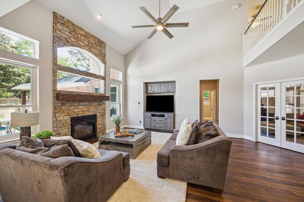 FAMILY ROOM Abundant natural light pours into this two story living area through wall of windows. All windows were replaced throughout the home by Anderson Windows, highly regarded and supremely efficient. Sellers spent more than $40,000 on this update. Tasteful stacked stone fireplace design stretches to the ceiling, providing a noteworthy focal point. Updated ceiling fan.