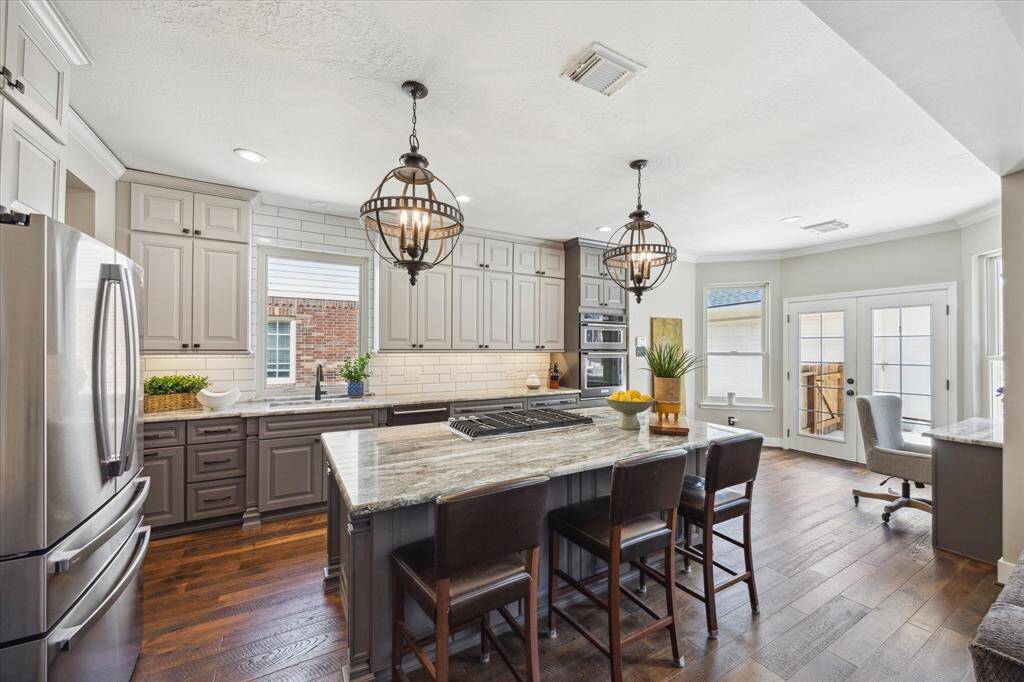 ALTERNATE VIEW OF KITCHEN The island kitchen is open to the family room so the chef will not miss out on any fun. Furniture grade cabinetry is plentiful and stretches to the ceiling.